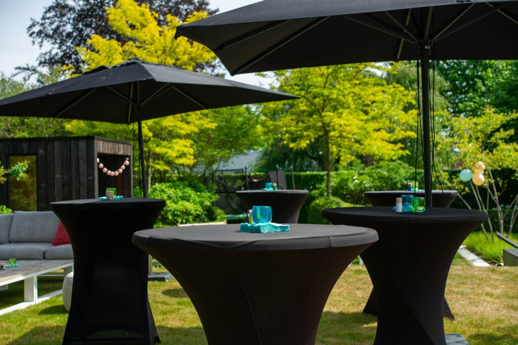 a couple of black tables sitting under umbrellas